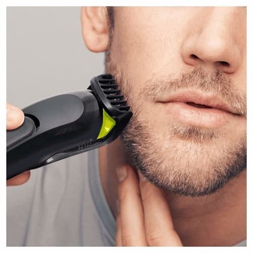 man using a beard trimmer on beard