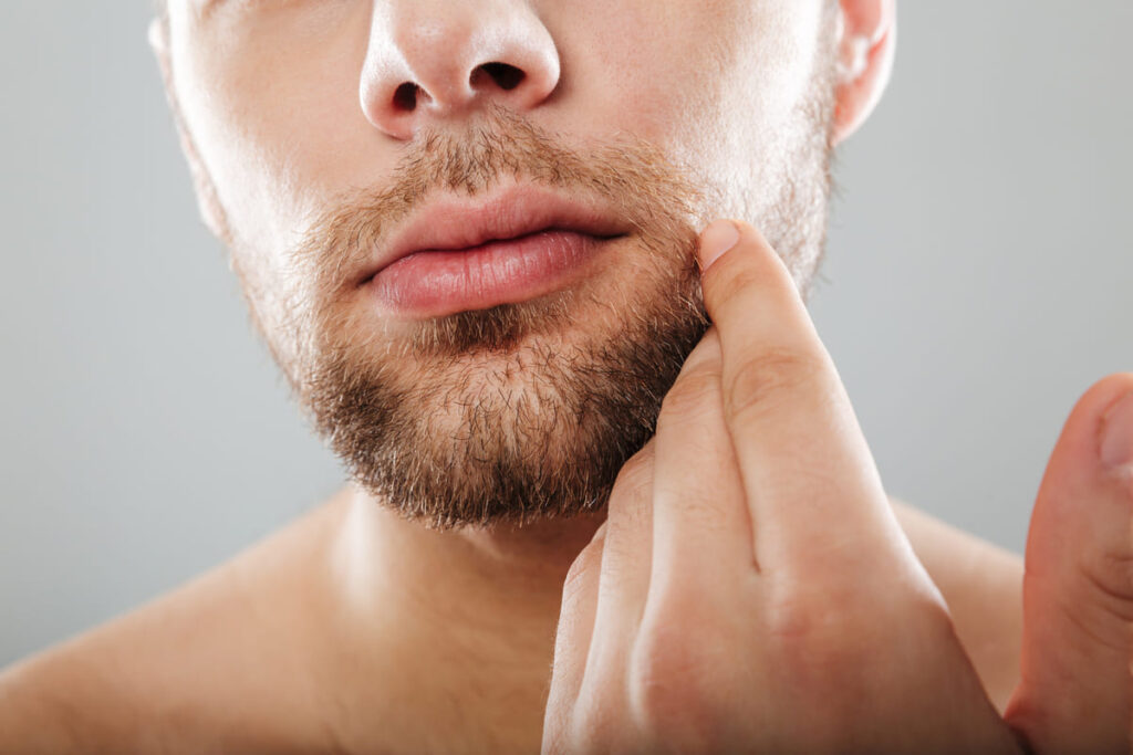 Young man working out how to stop beard itch