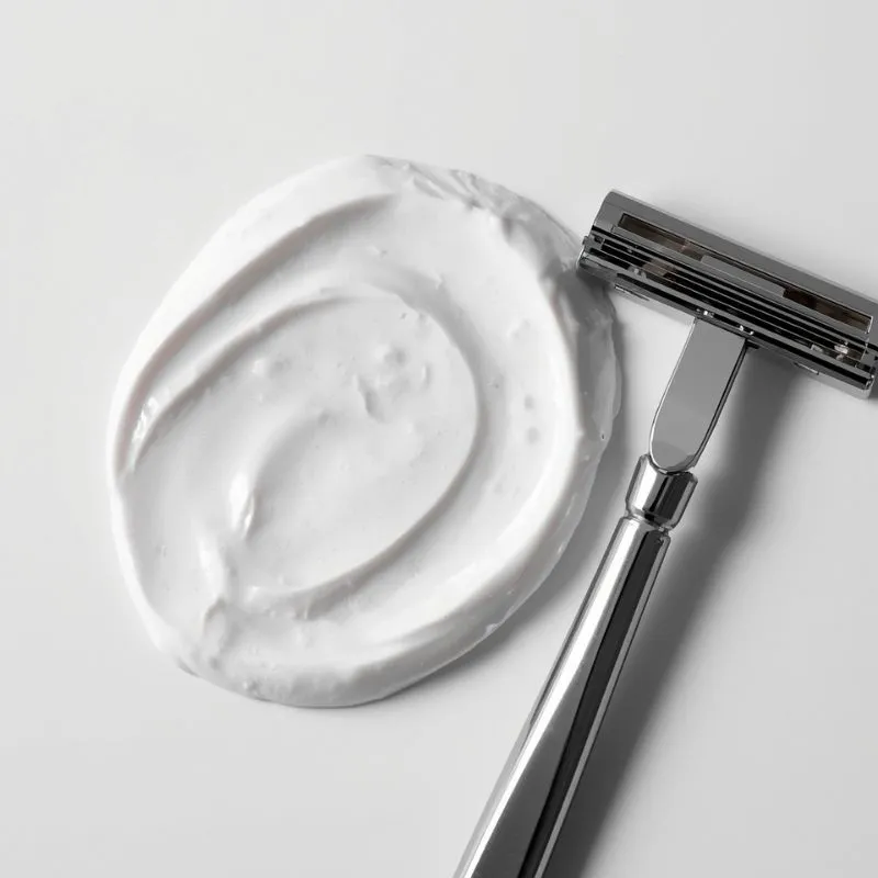 shaving cream swirl with a razor placed beside it