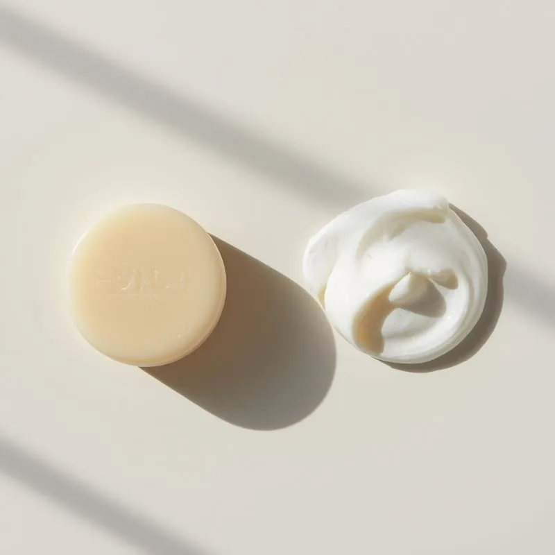 shaving soap puck and shaving cream swirl on a clean surface